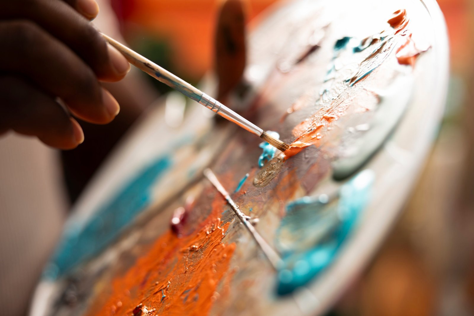 Painter mixes multiple watercolor paints on a palette to create a new artwork